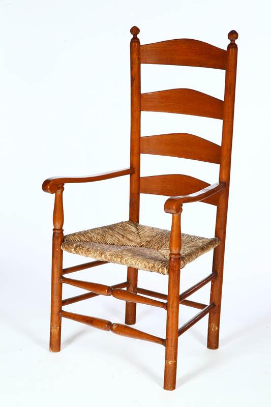 Appraisal: LADDERBACK ARMCHAIR American late th-early th century mixed woods Scrolled