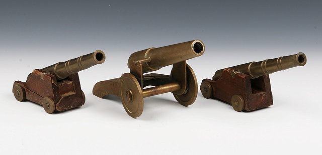 Appraisal: A PAIR OF MINIATURE TABLE TOP BRASS CANNONS each mounted