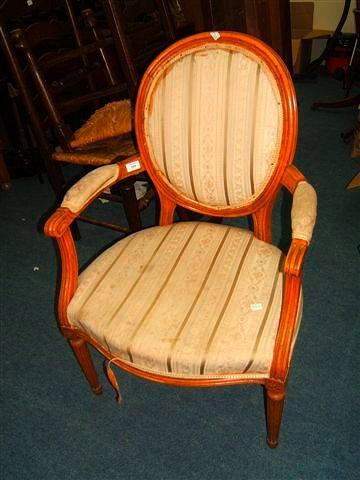 Appraisal: A Continental beechwood open armchair with oval upholstered back and