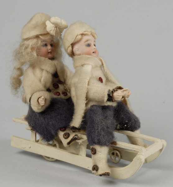 Appraisal: Bisque Head Boy and Girl on Sled Mechanical Toy Description