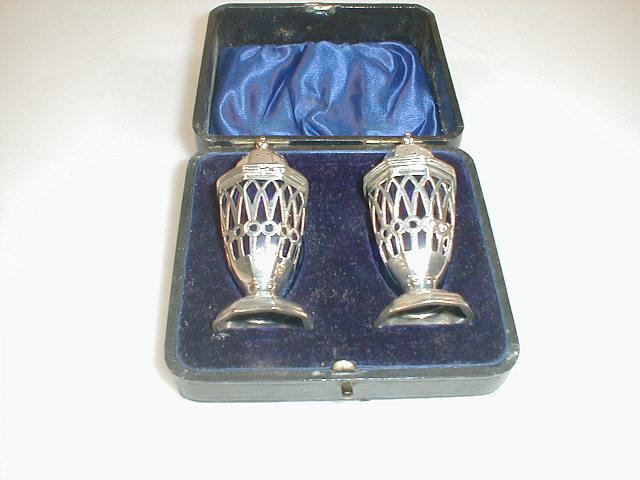 Appraisal: A cased pair of Edwardian silver pepperettes with pierced octagonal