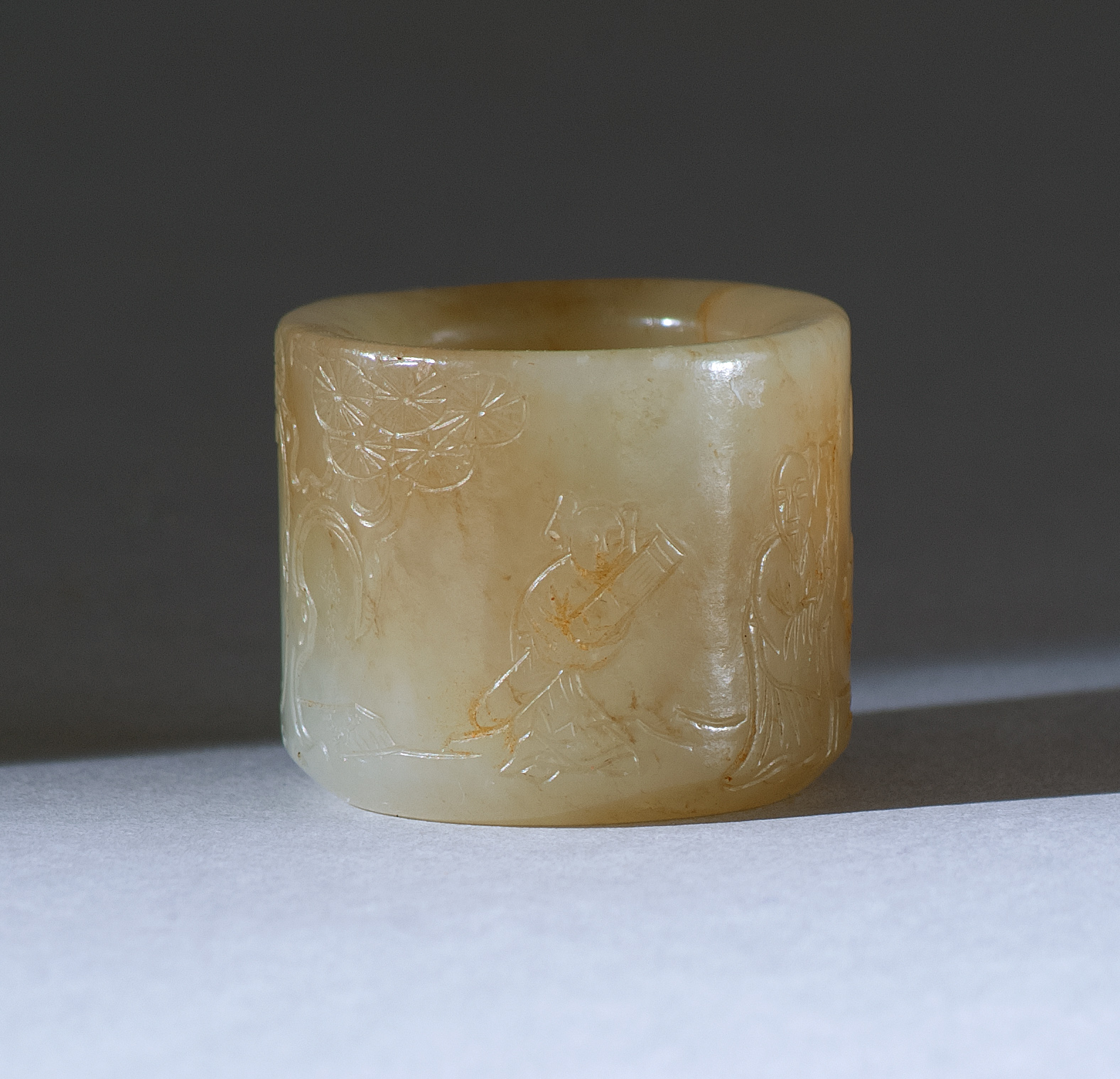 Appraisal: CELADON AND RUSSET JADE THUMB RING th CenturyDepicting a youth