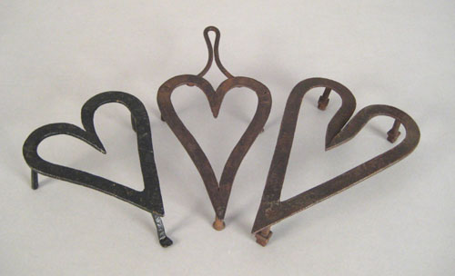 Appraisal: Two heart shaped wrought iron trivets th c one impressed