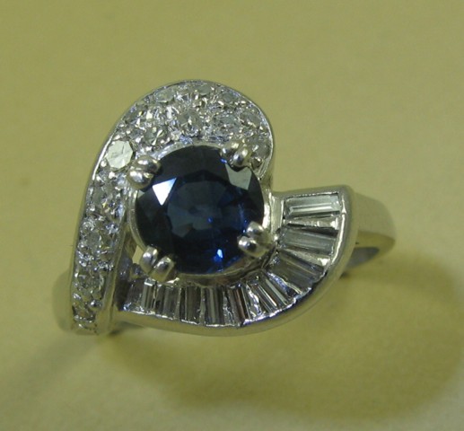 Appraisal: SAPPHIRE DIAMOND AND PLATINUM RING centering a round-cut blue sapphire