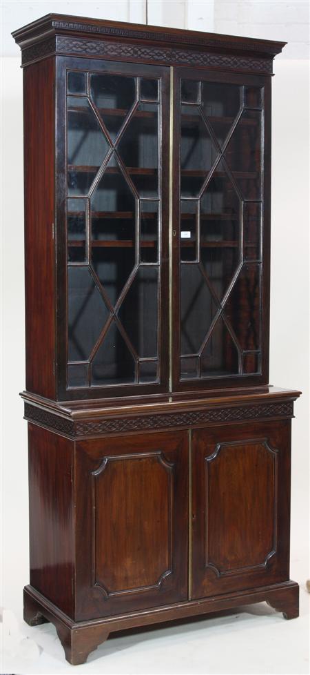 Appraisal: A mahogany bookcase the projected moulded greek key cornice over