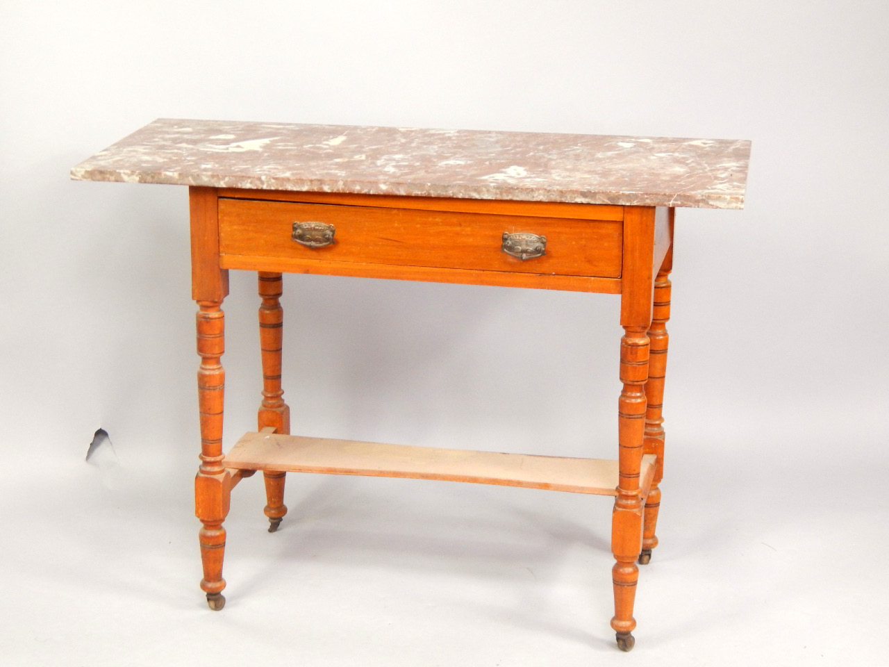 Appraisal: An Edwardian satin walnut washstand fitted with a frieze drawer