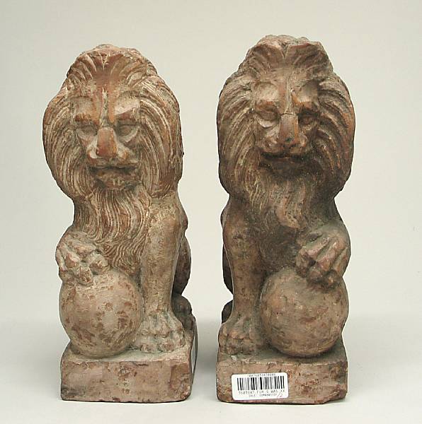 Appraisal: A pair of russet carved stone figures of lions th