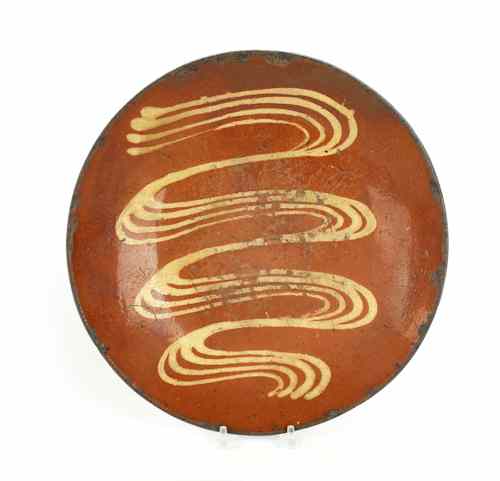 Appraisal: Pennsylvania redware charger th c with a wavy slip decorated