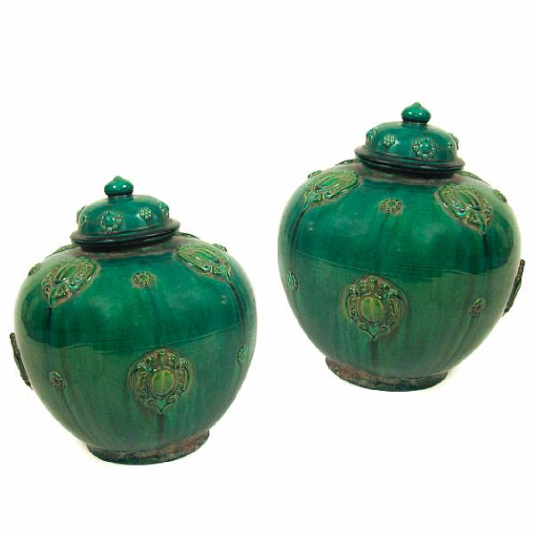 Appraisal: A pair of Chinese green glazed covered earthenware jars height