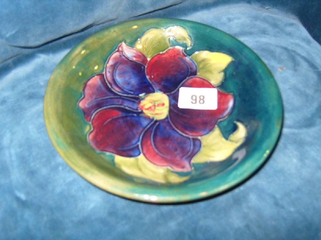 Appraisal: A green ground Moorcroft dish with painted purple and red