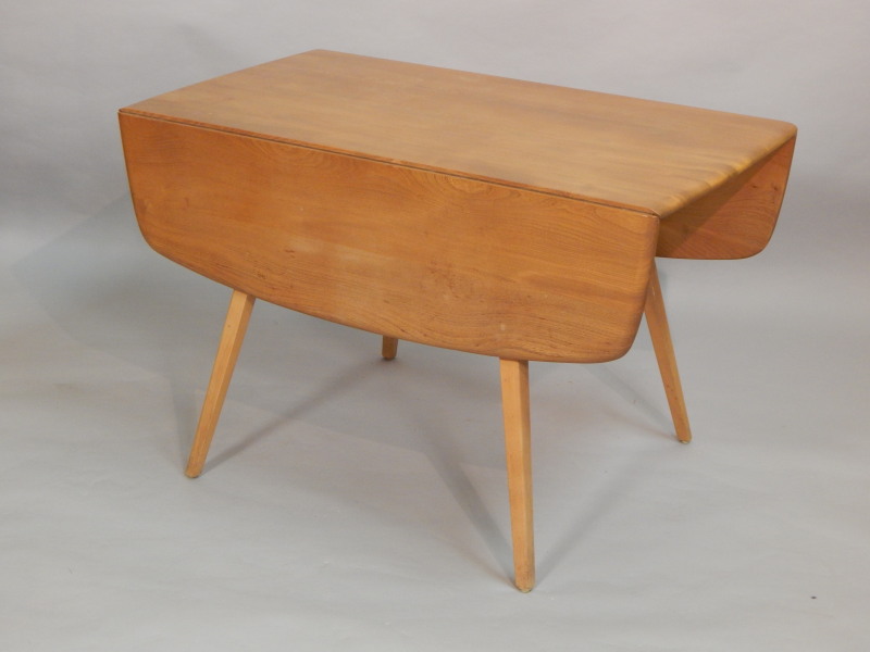 Appraisal: An Ercol light elm drop leaf table with a shaped