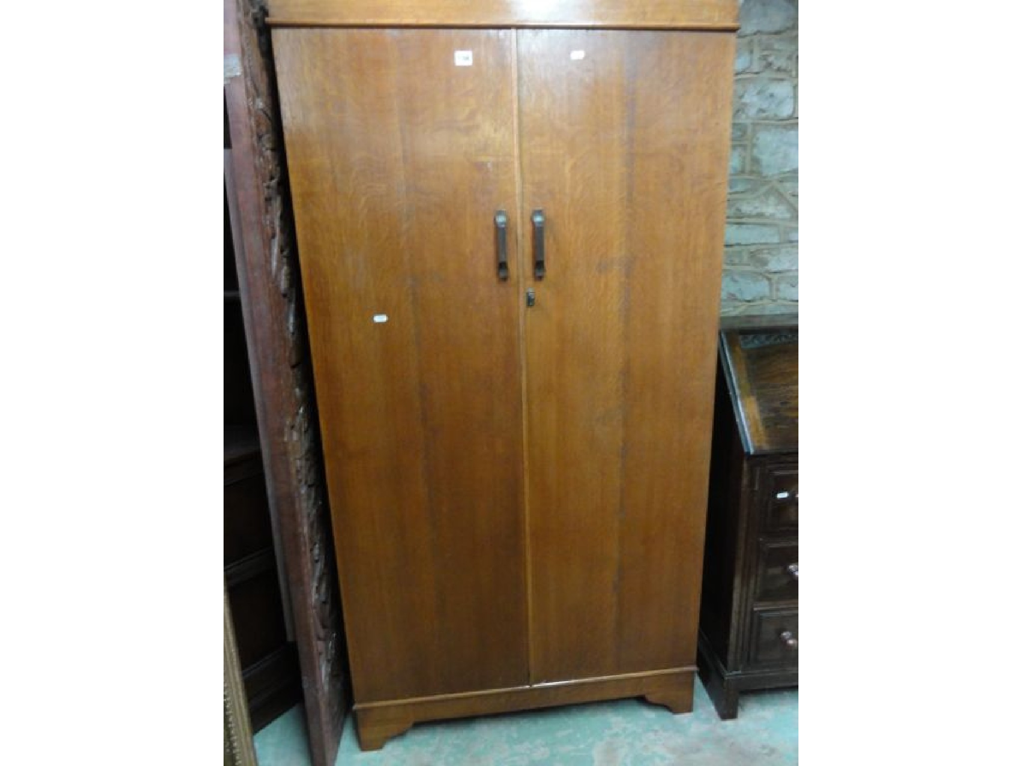 Appraisal: A small Art Deco style medium oak wardrobe enclosed by