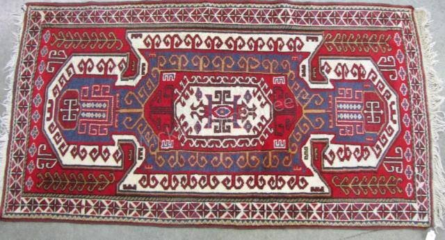 Appraisal: A handmade Oriental rug tribal motif red field with cream