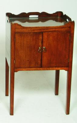 Appraisal: A MAHOGANY BEDSIDE CUPBOARD early th Century the wave edged