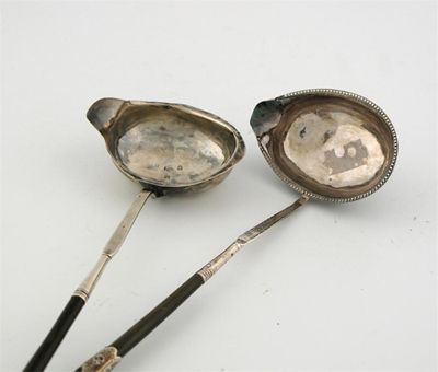 Appraisal: Two George III toddy ladles with twisted whalebone handles one