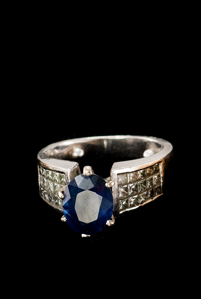 Appraisal: PLATINUM DIAMOND AND SAPPHIRE RING Faceted oval sapphire flanked by