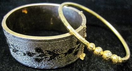 Appraisal: Two yellow gold banglesOne karat Italy the other gold fill