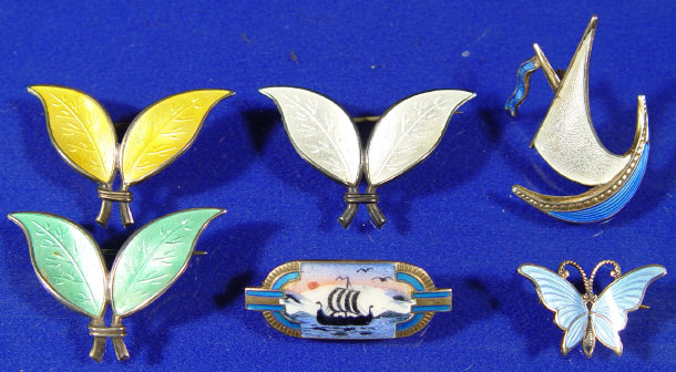 Appraisal: Two Norwegian sterling silver and enamel Viking longship brooches three