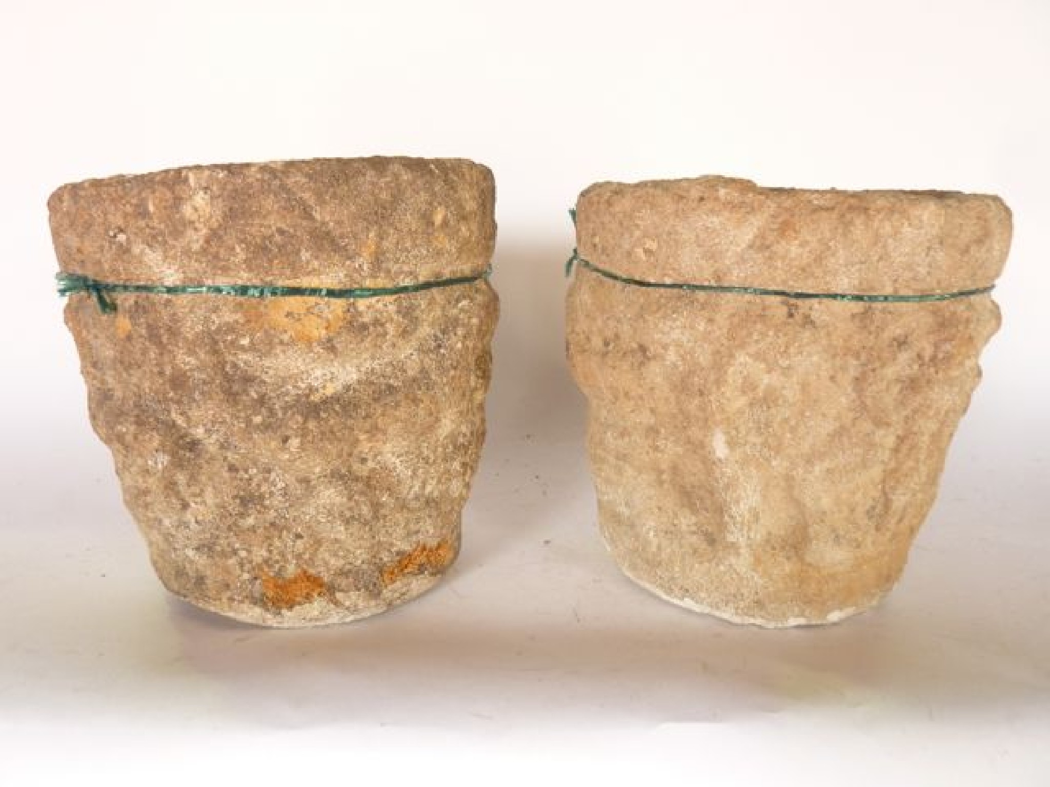 Appraisal: A pair of small weathered stone urns with character animal