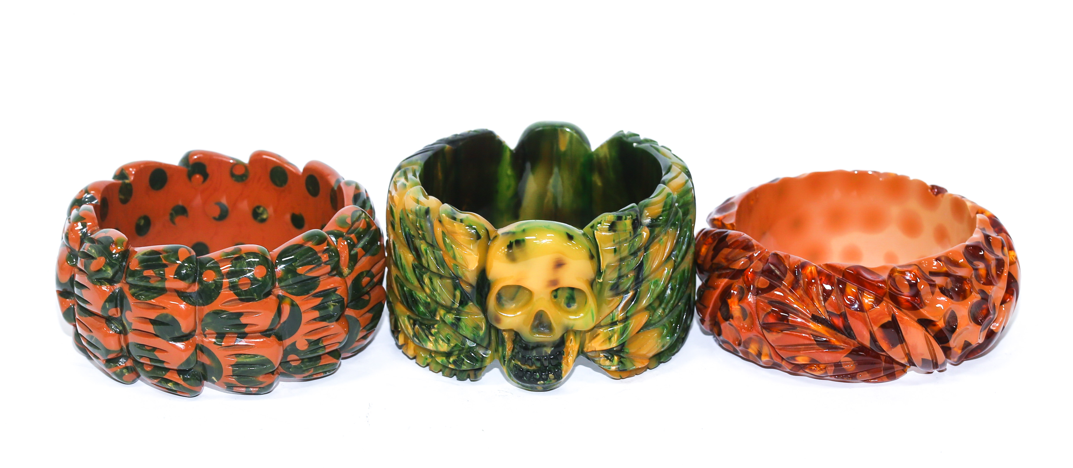 Appraisal: A TRIO OF WIDE BAKELITE BANGLES Including carved orange and