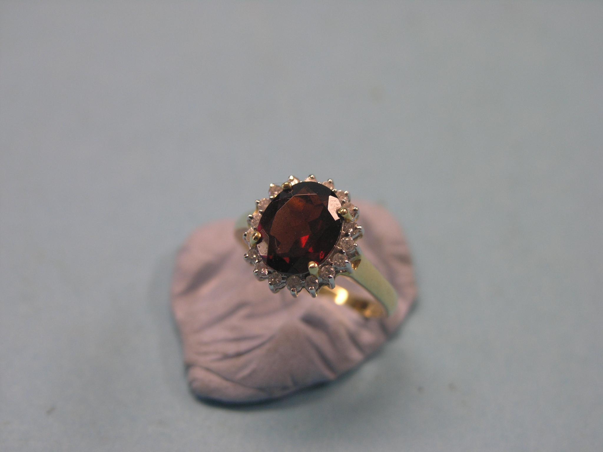 Appraisal: A modern ct gold cluster ring large central garnet surrounded