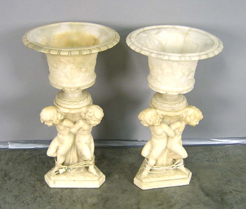 Appraisal: Pair of alabaster urns with putti bases h