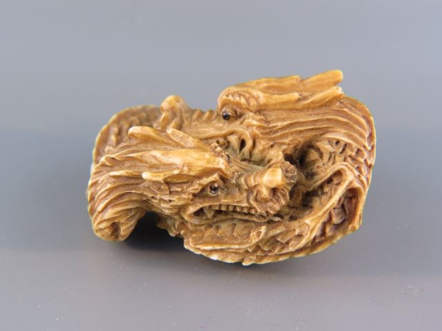 Appraisal: Carved Ivory Netsuke of Dragons onyx eyes X excellent