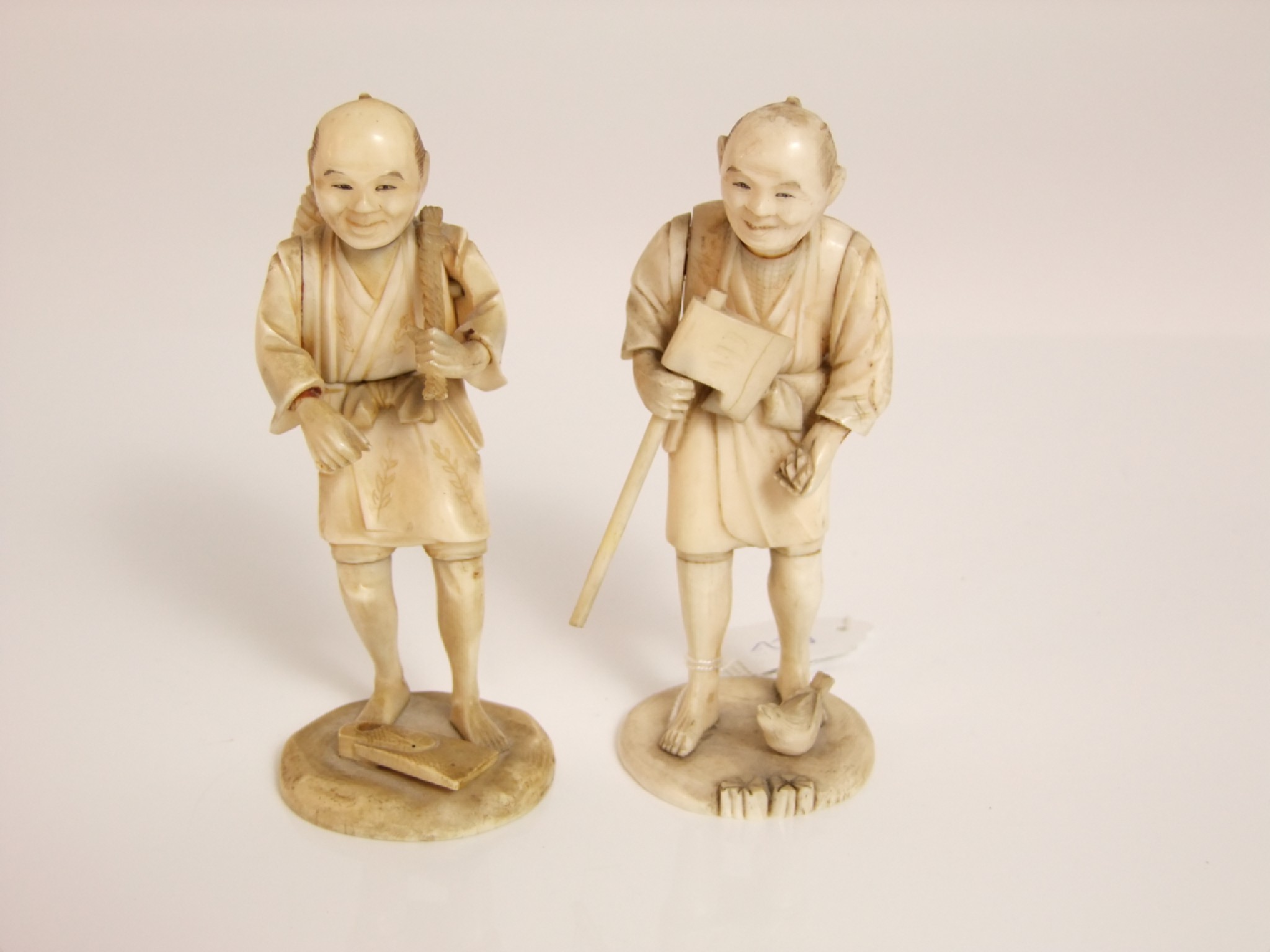 Appraisal: Two late th early th century Japanese carved ivory figures