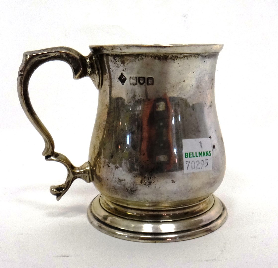 Appraisal: A silver mug of baluster form with a scrolling handle