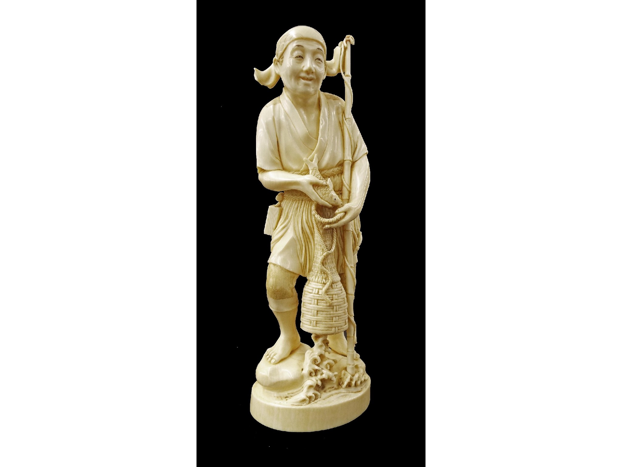 Appraisal: Japanese ivory okimono carved and modelled as a standing fisherman