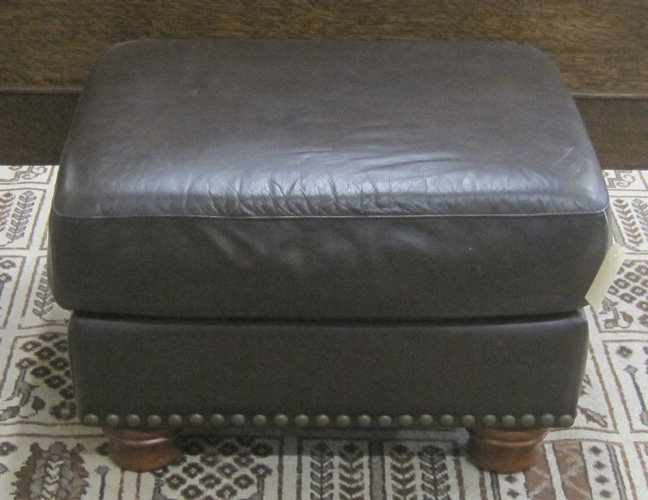 Appraisal: DARK BROWN LEATHER OTTOMAN rectangular form on four turned wood