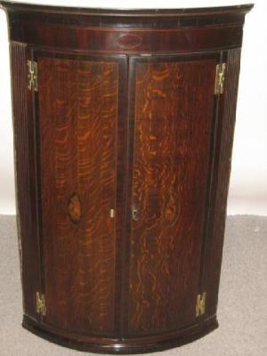 Appraisal: A GEORGE III OAK AND MAHOGANY CORNER CUPBOARD of quadrant