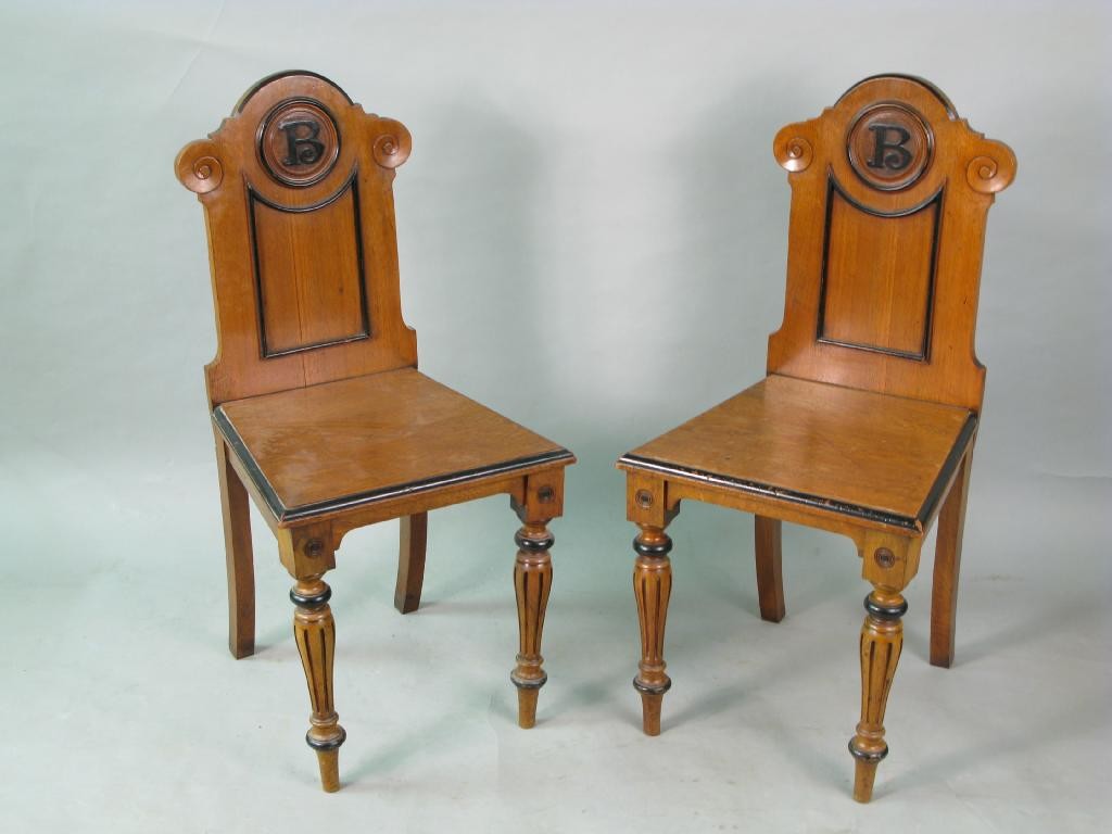 Appraisal: A pair of Victorian walnut hall chairs the backs with