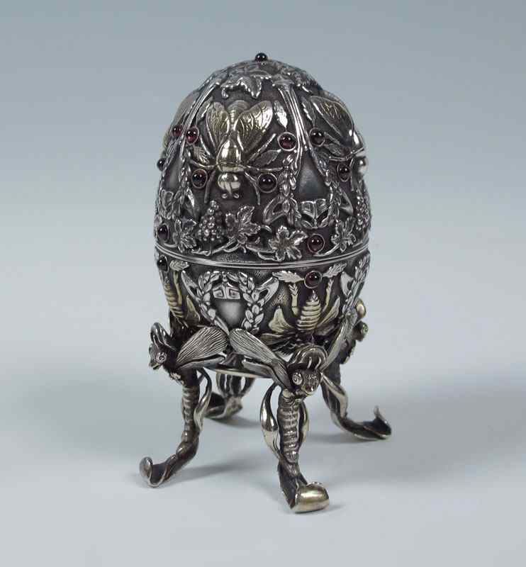 Appraisal: RUSSIAN SILVER AND GARNET FIGURAL EGG Hallmarked with Pavel Ovchinnikov