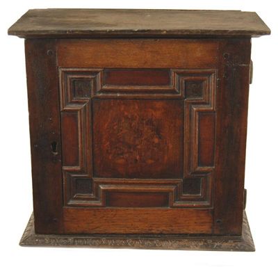 Appraisal: A small oak cupboard with a geometric panel door and