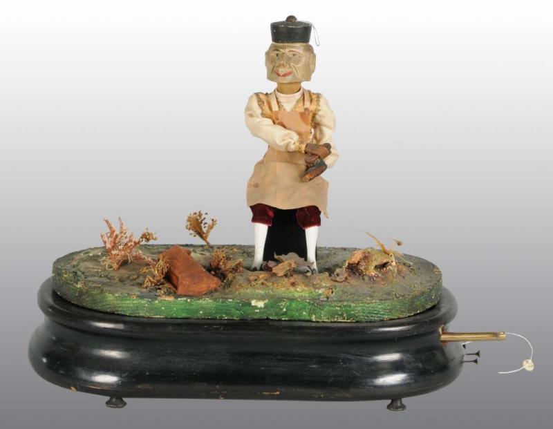 Appraisal: Shoemaker Automaton with Music Box Wind-Up Description European Working Clothing