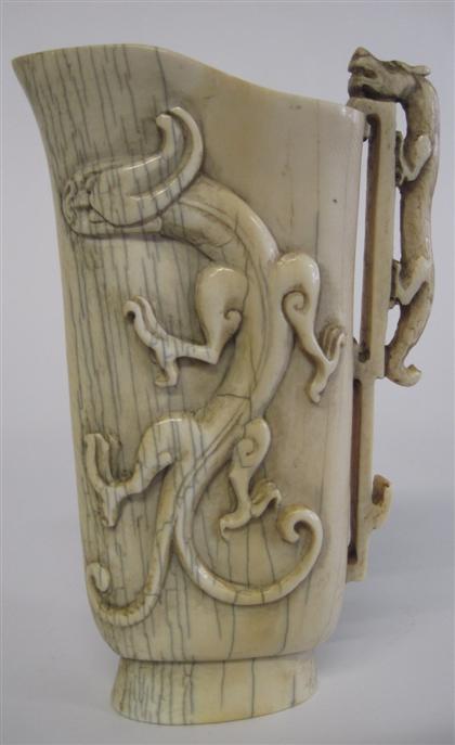 Appraisal: Chinese carved elephant ivory pouring vessel The archaic vessel of