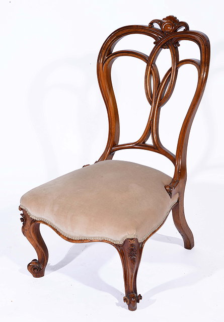 Appraisal: A VICTORIAN WALNUT LOW CHAIR with pierced and carved scrolling