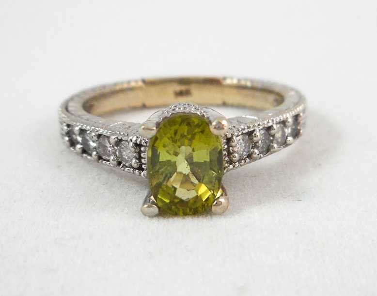 Appraisal: PERIDOT DIAMOND AND FOURTEEN KARAT WHITE GOLD RING with four