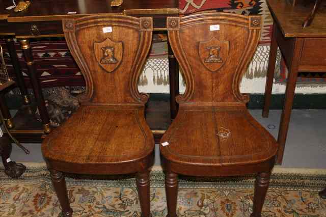 Appraisal: A PAIR OF TH CENTURY OAK HALL CHAIRS the shield