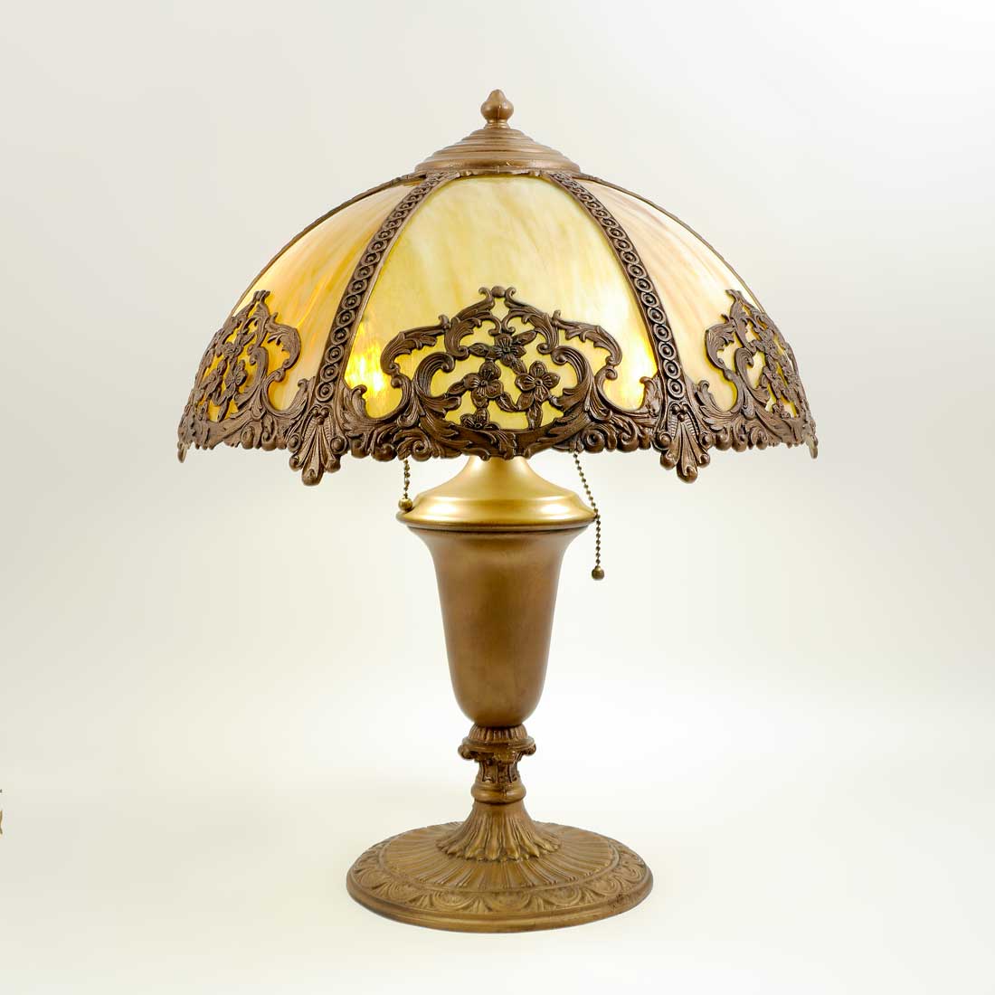 Appraisal: CARAMEL SLAG GLASS BENT PANEL LAMP Gold decorated cast iron