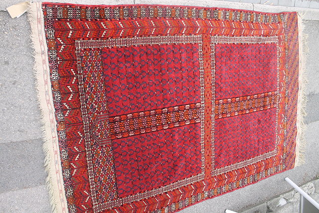 Appraisal: AN AFGHAN RED GROUND RUG with central geometric panel