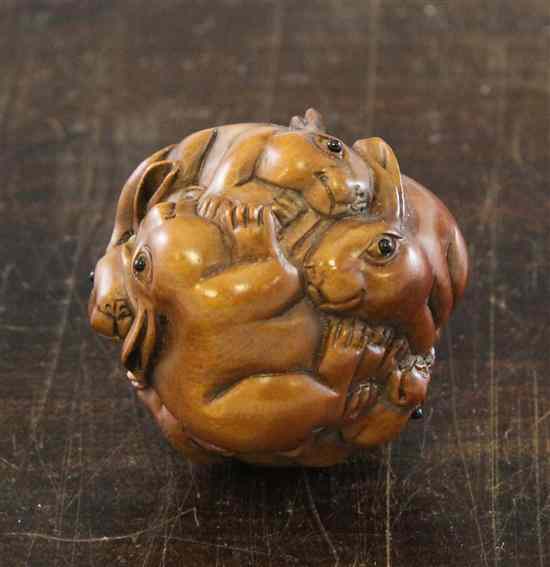 Appraisal: A hardwood netsuke carved as an orb of rabbits with