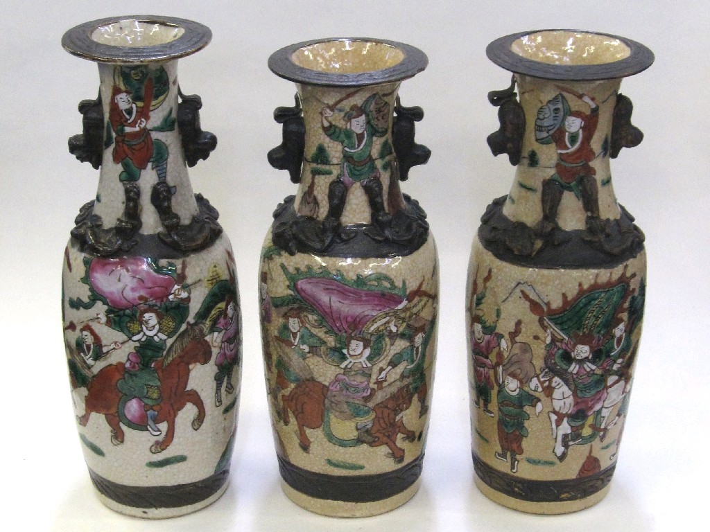 Appraisal: Three Oriental pottery vases each decorated with warriors on a