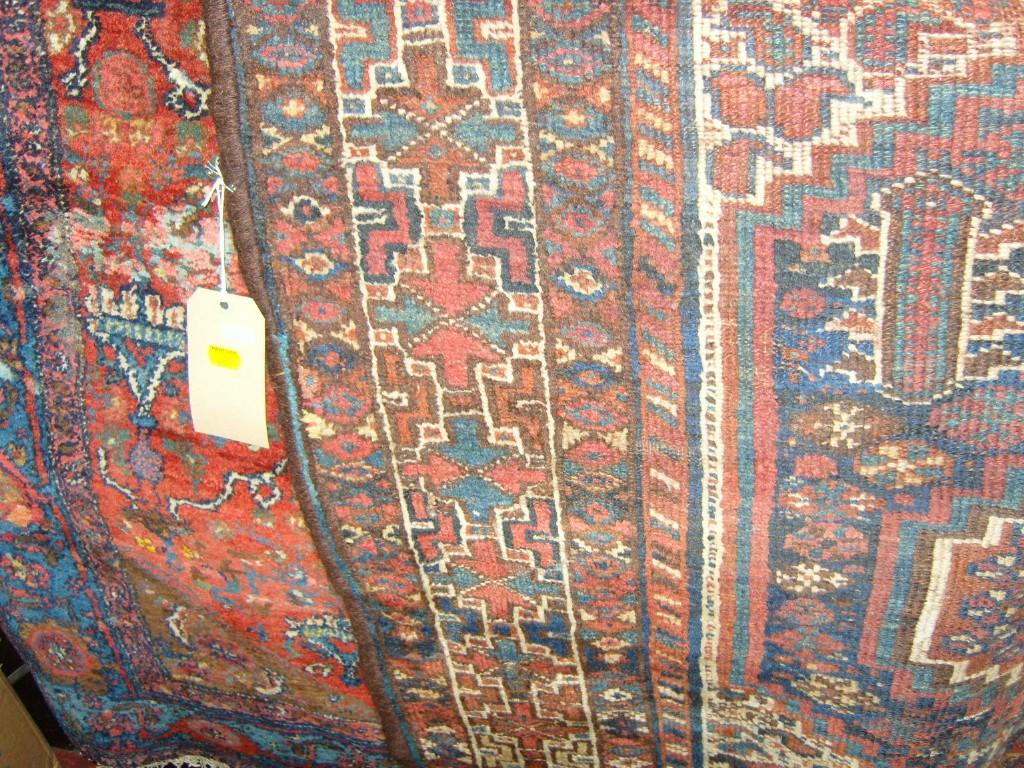 Appraisal: Two red ground eastern wool rugs with hooked and geometric