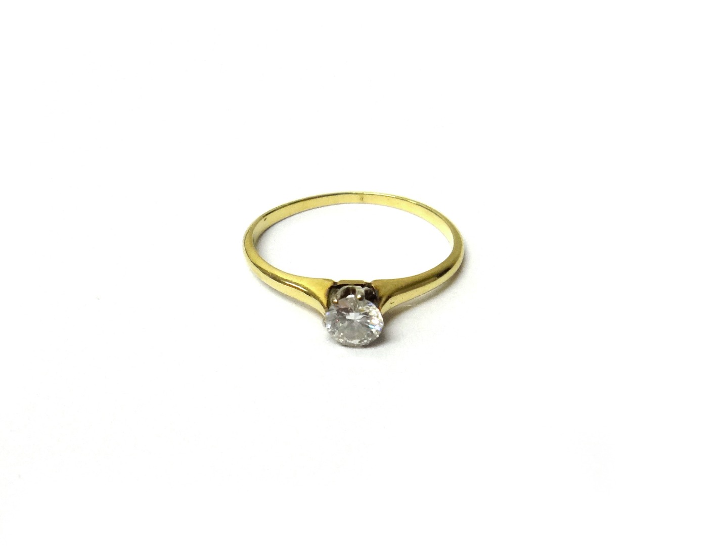 Appraisal: A gold and diamond single stone ring claw set with