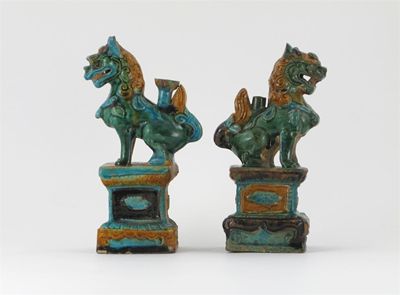 Appraisal: Two Chinese pottery taper sticks modelled as fabulous animals raised