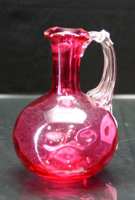 Appraisal: Victorian dimpled cranberry glass jug with reeded clear glass handle