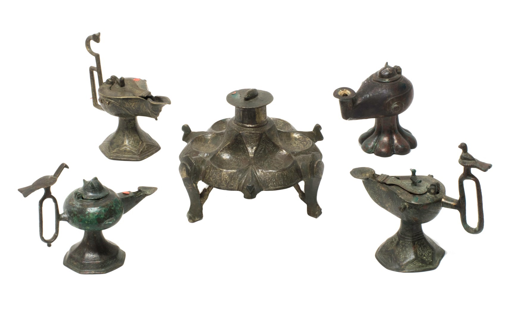 Appraisal: Four Persian bronze oil lamps and a candleholder stand mostly