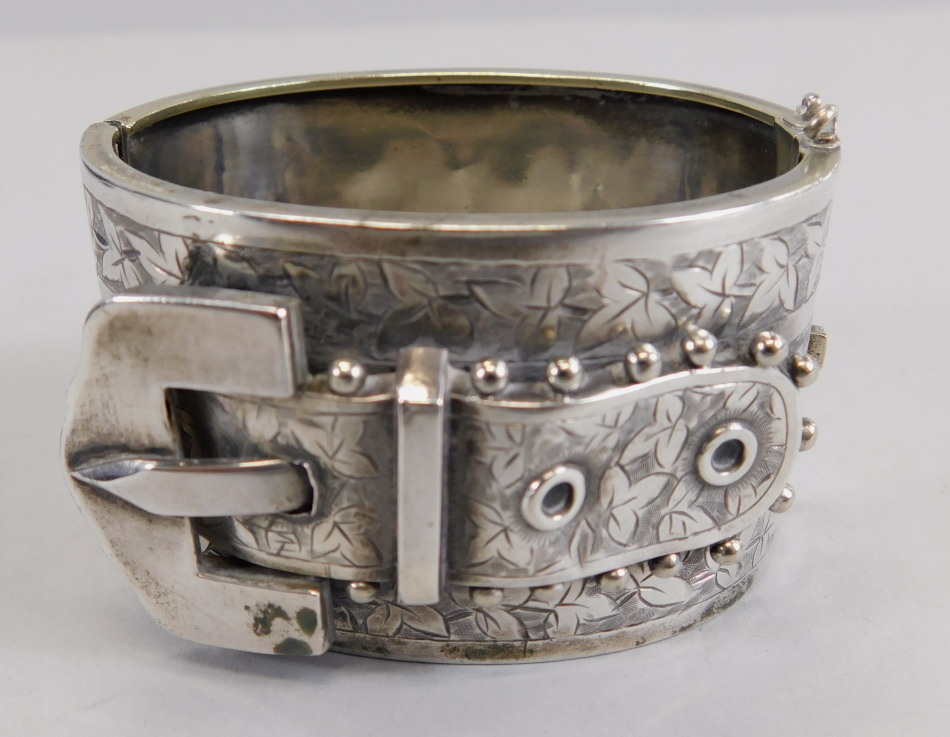 Appraisal: A silver buckle bangle the raised buckle with floral engraved